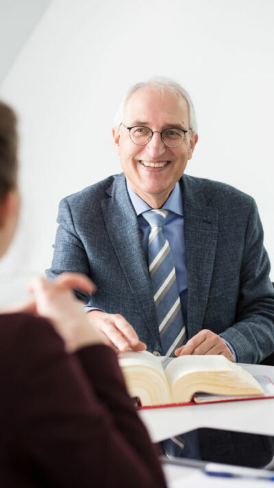 Steuerberater Herbert Prinz berät eine Mandantin am Schreibtisch